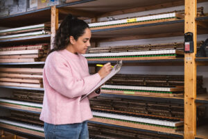 Juliana Chupp taking inventory of piano actions in process at the Chupp's Piano Service, Inc. Showroom and Rebuilding Facility.